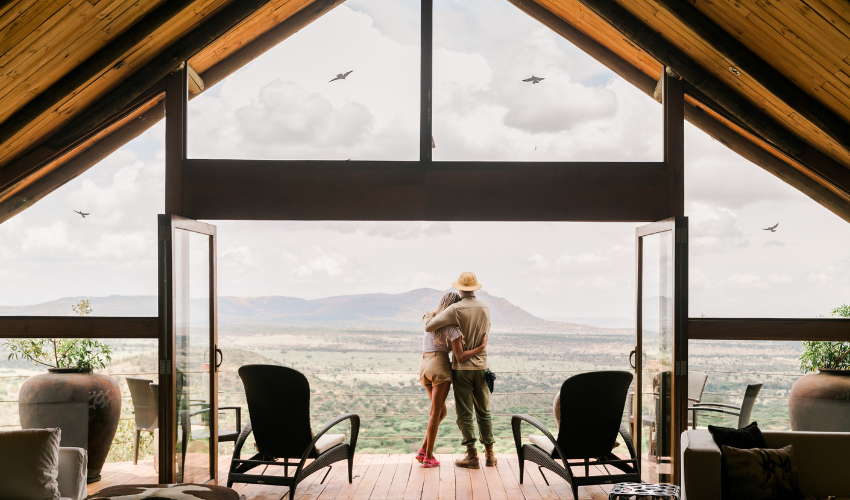 Couple look out over the Maasai Mara from their private villa